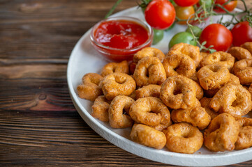 handmade tortellini with tomatoes and thyme greens on a white plate is called taralli. taralli in Italian bakeries in southern Italy on a wooden background.