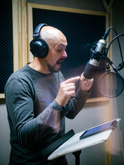 Expressive face of bald man near microphone