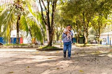 Fototapeta na wymiar 8-10 year old boy walking with a dog in the park