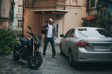 Obraz na płótnie Canvas Bald man on narrow South style line cant choice between car and motorcycle