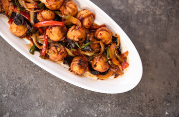 .fried dumplings in a white plate on a concrete background
