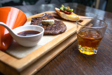.whiskey and steak with sauce on wood