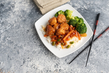 Orange chicken stir fry served with broccoli and rice
