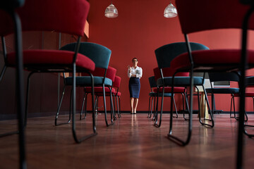 Woman standing infront chairs in office