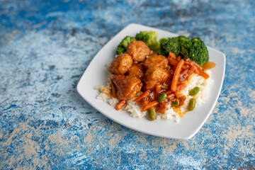 Orange chicken stir fry served with broccoli and rice