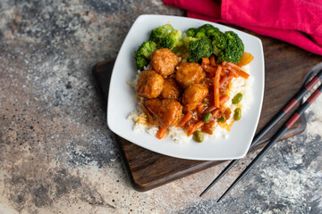 Orange chicken stir fry served with broccoli and rice