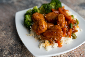 Orange chicken stir fry served with broccoli and rice