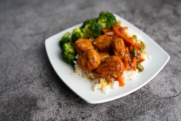 Orange chicken stir fry served with broccoli and rice