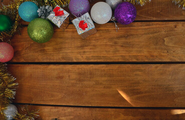 New Year's layout on a wooden background. Christmas decorations for the tree, balls, gifts.