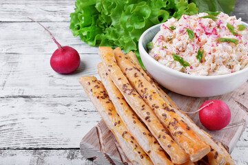 Cottage cheese pate with radish and green onion and bread sticks on the white table