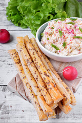 Cottage cheese pate with radish and green onion and bread sticks on the white table
