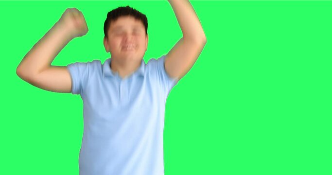 Exited young boy jumping agains green screen background