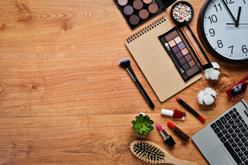 female wooden desktop with Laptop, notepad, Lipstick, powder, comb, women's jewelry. Top view. Free space for your text. Flat lay.