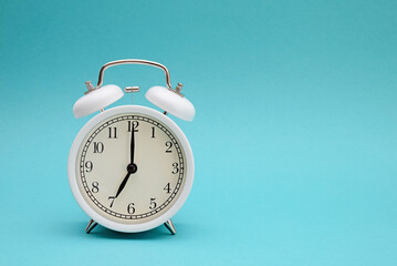 White alarm clock photography on blue background