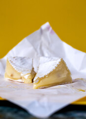 .slices of sliced ​​camembert cheese on yellow background