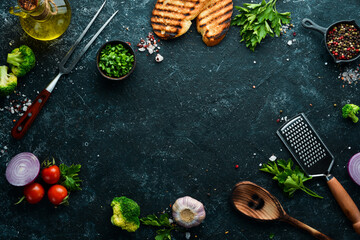 Black food background. Vegetables and spices on black background. Top view. Free space for your text.