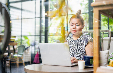 Lifestyle, Asian woman smiling sitting using laptop working in coffee shop and workspace