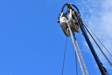 Winch with rope on a blue sky background. Part of the ship's equipment. lifting mechanism in a fishermen boat.  © Tetiana Ivanova