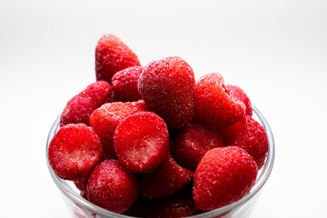 Pedazos de fresas frescas  en vaso sobre fondo blanco
