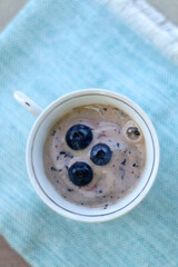 Banana and blueberry vegan nice cream, served in a vintage porcelain cup. Top view.
