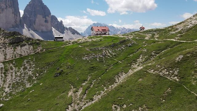 4k video of the Tre Cime di Lavaredo, italian dolomites Alps mountains. beautiful and imposing rock pyramids that stand out in the sky, unspoiled nature, famous Locatelli refuge. breathtaking panorama