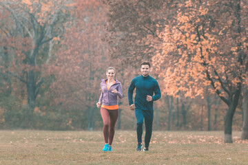 Couple in wonderful fall landscape running for better fitness
