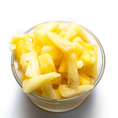 Pedazos de piña fresca y congeladas con plantas de fondo