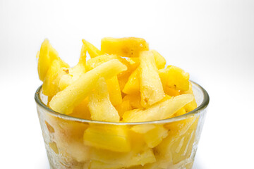 Pedazos de piña fresca y congeladas con plantas de fondo