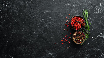 Assortment of peppers and spices on a dark background. Top view. Free space for your text.