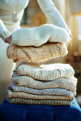 Closeup on modern housewife prepare sweaters pile for storage