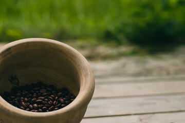 Wooden bowl filled with coffee with green background