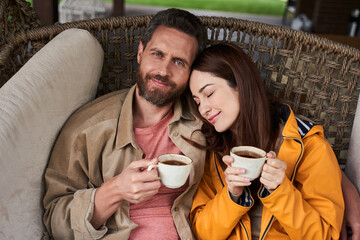 Happy husband and wife drinking tea outdoors