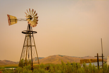 An old country windmill in a rancher's field in Idaho during a fallout of smoke and ash from fires...