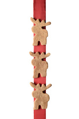 Three moose shaped cookies on a red ribbon isolated on white.