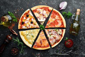Assortment of pizza sliced on black stone background. Top view. free space for your text. Rustic style.
