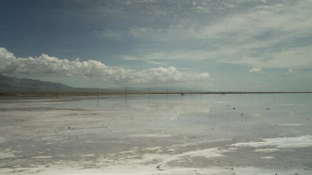 Chaka Salt Lake with Sky and Clouds Reflected in Water - Slow Pan Across - Qinghai Xining Ulan County China