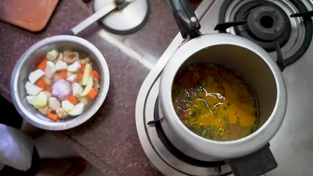 Dish In A Pot Over The Stove With Chopped Ingredients On Its Side. - High Angle Shot