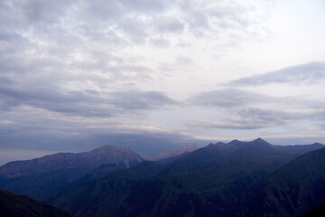 Silhouettes of mountains in the evening haze. Mountain ranges at sunset. Dusk.