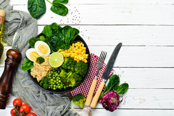 Green vegetable bowl Buddha. quinoa, green peas, corn, spinach, broccoli, egg. Healthy food. Top view. Free space for your text.