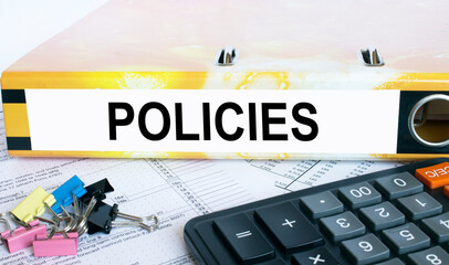 Text Policies on the folder that is located on the financial reports with calculator and stationery...