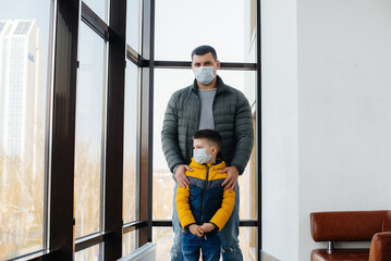 A father with his child stands in a mask during the quarantine. Pandemic, coronavirus