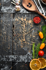 Dark old culinary background with vegetables and spices. Top view. Free space for text.