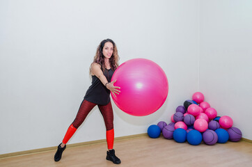 Fototapeta na wymiar sport, training and lifestyle concept - beautiful woman with fitness ball in the gym.