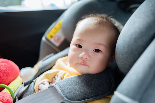 portrait of cute baby girl in safety seats in car