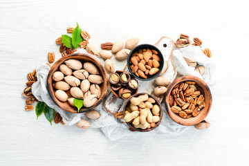 Set of nuts. pecans and macadamia nuts in bowls on a white background. Top view. Free space for your text.