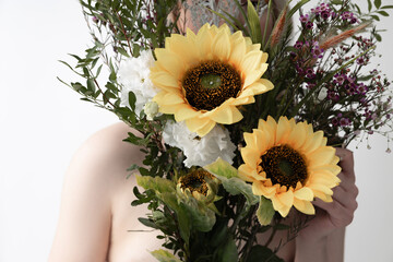 Young woman holding beautiful bouquet with sunflowers