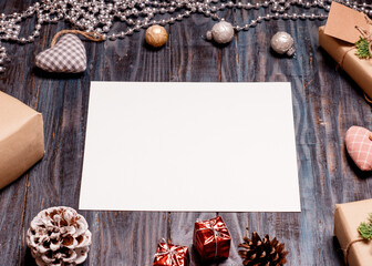 White paper, Christmas decoration, and gifts on wooden background