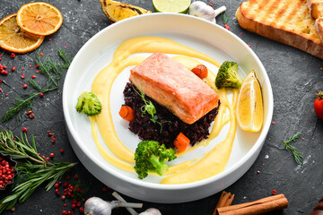 Baked salmon fillet with wild rice and vegetables. Top view. Free space for text.