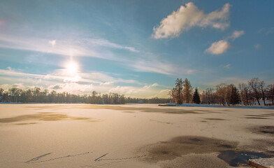 Winter landscape, the lake is covered with white snow.