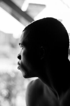 Fototapeta Portrait of a young man looking trough the window